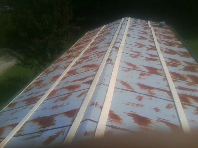 Rusted metal roof panels with new wood purlins before replacement — Storm Damage Roof Repair in Glens Falls by Roofing Brothers